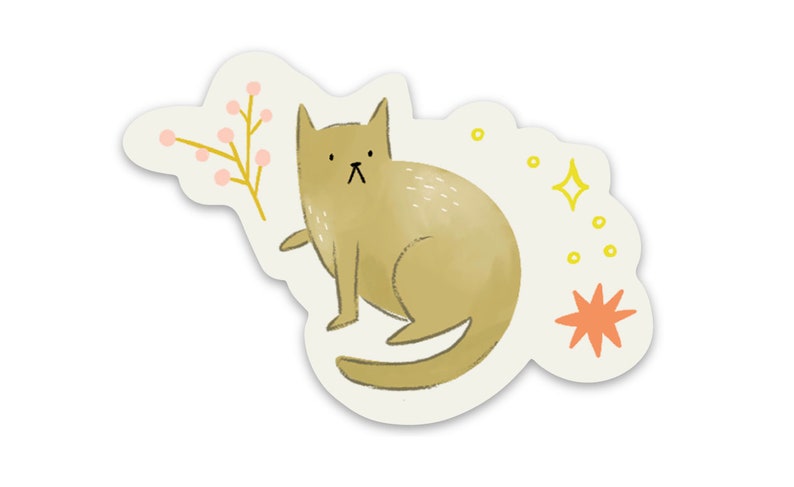 Op de afbeelding: Een grillige sticker met een illustratie van een bruine kat met een ietwat humeurige uitdrukking. De kat is omringd door decoratieve elementen, waaronder een takje met roze bessen, gele sterren en een oranje ster. De sticker heeft een witte rand.