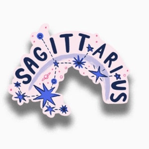May include: A pink sticker with the word "Sagittarius" written in a blue and white font. The sticker features a constellation design with blue stars and a purple and white rainbow.
