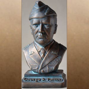 May include: A bronze bust of General George S. Patton, wearing a military uniform and cap. The bust is on a base with the inscription "George S. Patton".