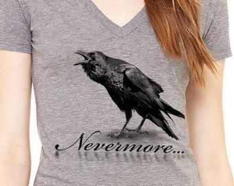 May include: A heather gray V-neck t-shirt with a black raven illustration and the text "Nevermore..." printed on the front.