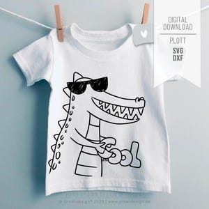 May include: White t-shirt featuring a black and white cartoon alligator wearing sunglasses and holding the word "cool". The shirt is hanging from a clothesline with a wooden clip. The text "DIGITAL DOWNLOAD" is visible.