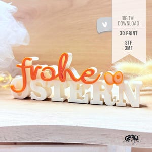 Puede incluir: Un letrero impreso en 3D con las palabras alemanas "Frohe Ostern" en blanco y naranja. El letrero está sobre una superficie de madera e incluye el texto "DIGITAL DOWNLOAD", "3D PRINT", "STF" y "3MF".