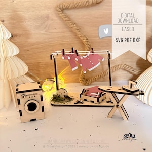 May include: A miniature wooden laundry set, including a washing machine, clothesline, ironing board, and a small bed. The clothesline displays pink clothing. The image includes the text "DIGITAL DOWNLOAD LASER SVG PDF DXF".