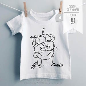 May include: White toddler t-shirt featuring a black and white cartoon acorn character with a smiling face, arms akimbo, and leaf accents. The shirt is hanging from a clothesline with a wooden clothespin. Text on the shirt reads "HAND DRAWN DESIGN WITH LOVE".