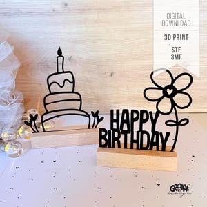 Peut inclure: Deux enseignes décoratives noires imprimées en 3D avec des bases en bois. L'une présente le contour d'un gâteau d'anniversaire à étages, l'autre affiche le texte HAPPY BIRTHDAY avec une fleur. L'image contient le texte DIGITAL DOWNLOAD 3D PRINT STF 3MF.