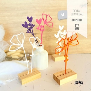 Könnte beinhalten: Eine Sammlung farbenfroher 3D-gedruckter Blumendekorationen. Die Blumen sind in verschiedenen Farben erhältlich, darunter Weiß, Lila, Rosa und Orange, und sind auf kleinen Holzblöcken montiert. Das Bild enthält auch eine weiße Vase und Text mit der Aufschrift "DIGITALER DOWNLOAD" und "3D-DRUCK".