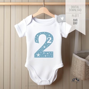 May include: White baby onesie with a light blue number 2 design filled with stars. The onesie is hanging on a wooden hanger. The words "DIGITAL DOWNLOAD" and "PLOTT SVG DXF" are printed on a white tag.