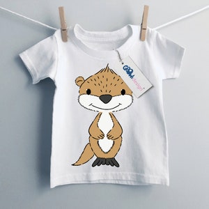 May include: White baby t-shirt featuring a brown cartoon otter graphic. The otter is smiling and has a brown nose and black eyes. The t-shirt has a tag that says "GROWdesign*"
