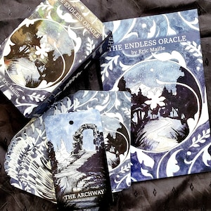 May include: The Endless Oracle deck and guidebook by Eric Maille. The box, book, and cards feature a blue and white floral design. The cards show a snowy landscape with an archway and the text "THE ARCHWAY".