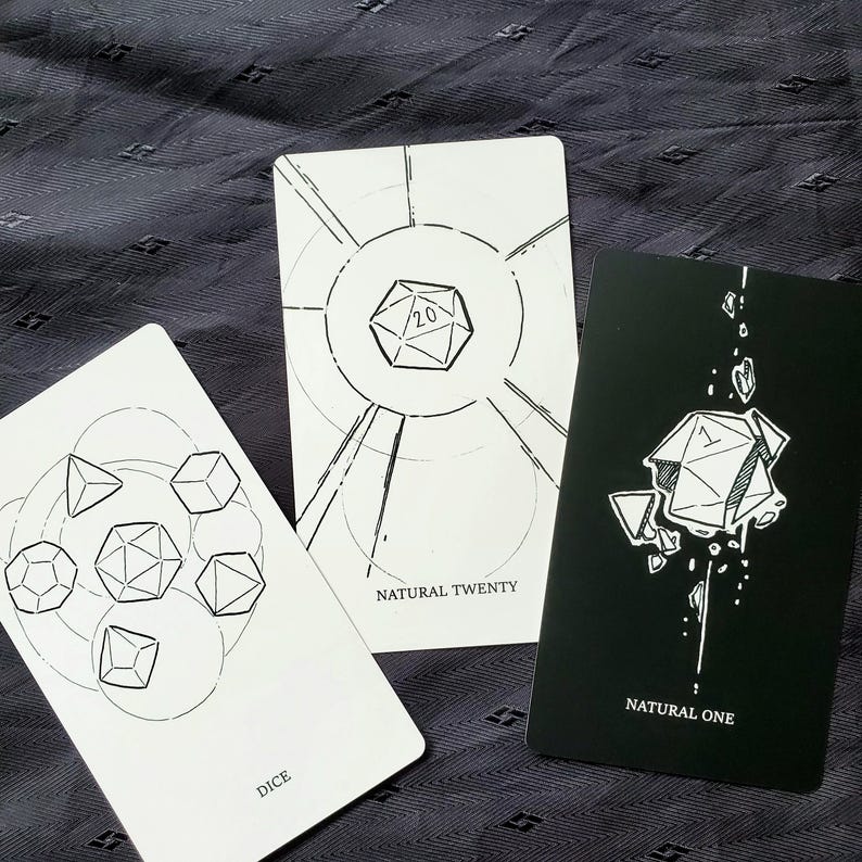 Puede incluir: Tres cartas con ilustraciones geom&eacute;tricas de dados. Una carta dice "DICE", otra "NATURAL TWENTY" y la tercera "NATURAL ONE". Las cartas son blancas con dibujos lineales negros y una carta negra con dibujos lineales blancos.