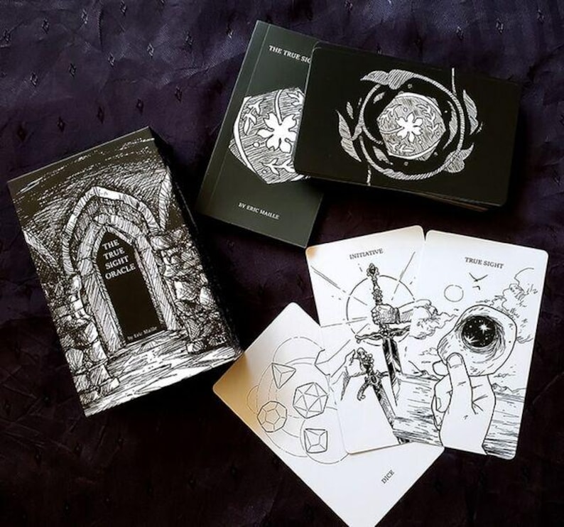 Puede incluir: Una baraja de or&aacute;culo en blanco y negro con el t&iacute;tulo "The True Sight Oracle" en la caja y las cartas. Las cartas presentan ilustraciones en blanco y negro y las palabras "Initiative", "True Sight" y "Dice". La baraja se muestra sobre una superficie morada oscura.