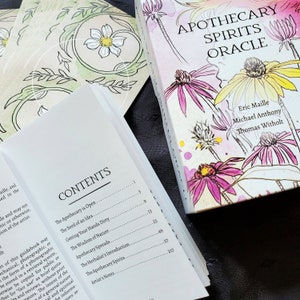 K&ouml;nnte beinhalten: Eine wei&szlig;e Box mit einem pinkfarbenen, gelben und gr&uuml;nen Blumendesign. Die Box tr&auml;gt den Titel "Apothecary Spirits Oracle" und zeigt die Namen Eric Maille, Michael Anthony und Thomas Witholt. Die Box ist ge&ouml;ffnet und zeigt ein Buch mit einem Inhaltsverzeichnis mit dem Titel "Contents".