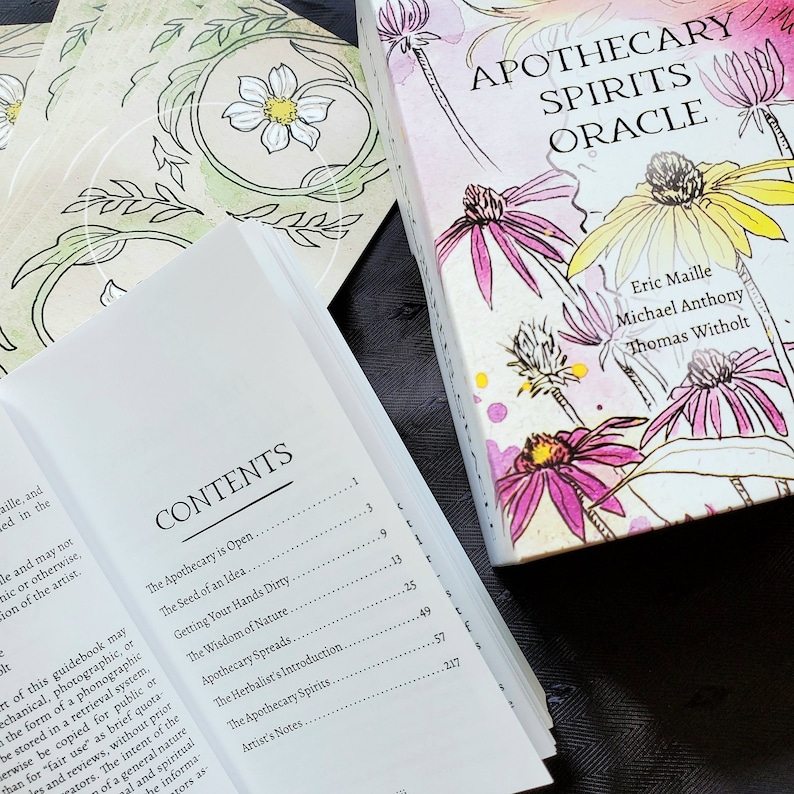 K&ouml;nnte beinhalten: Eine wei&szlig;e Box mit einem pinkfarbenen, gelben und gr&uuml;nen Blumendesign. Die Box tr&auml;gt den Titel "Apothecary Spirits Oracle" und zeigt die Namen Eric Maille, Michael Anthony und Thomas Witholt. Die Box ist ge&ouml;ffnet und zeigt ein Buch mit einem Inhaltsverzeichnis mit dem Titel "Contents".