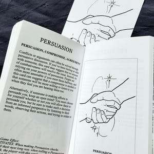 Puede incluir: Libro abierto con la palabra "PERSUASION" en la p&aacute;gina. El texto describe la persuasi&oacute;n, el compromiso y el acuerdo. Tambi&eacute;n se ve una ilustraci&oacute;n en blanco y negro de dos manos estrech&aacute;ndose.
