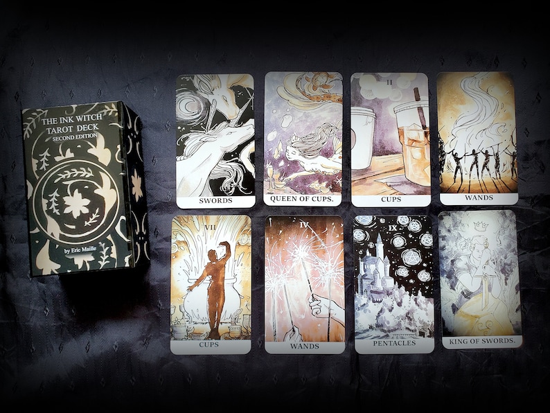 Pu&ograve; includere: Una scatola di mazzo di tarocchi con il titolo "The Ink Witch Tarot Deck, Second Edition" di Eric Maille. La scatola &egrave; nera con un design floreale dorato. Le carte dei tarocchi sono disposte su una superficie scura. Le carte presentano illustrazioni di spade, coppe, bastoni e pentacoli.