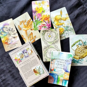 K&ouml;nnte beinhalten: Ein Satz Orakelkarten mit Aquarell-Illustrationen von Pflanzen und Blumen. Die Karten sind Teil des Apothecary Spirits Oracle-Decks. Das Handbuch ist ebenfalls abgebildet mit einer Aquarell-Illustration von Kr&auml;utern und Gl&auml;sern.