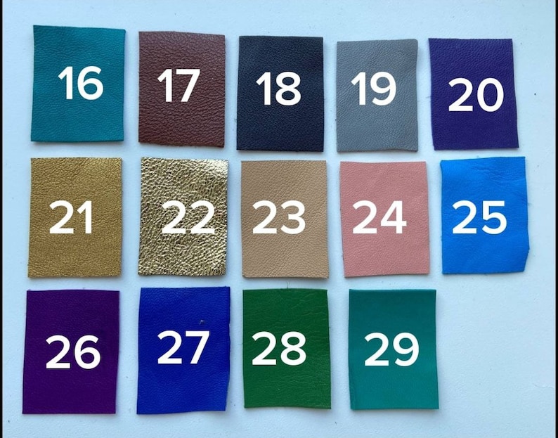 May include: A collection of 14 different colored leather swatches numbered 16 through 29. The swatches are arranged in three rows of four and one row of two.