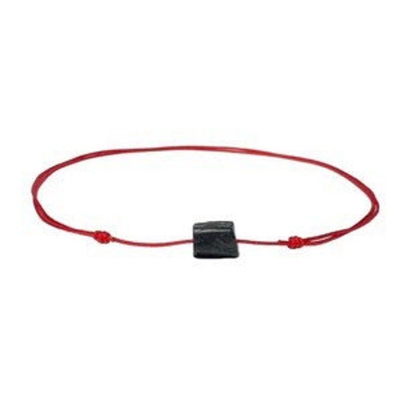 Puede incluir: Un collar con un colgante de piedra negra en un cord&oacute;n rojo.