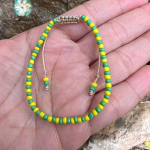 Bracciale Orula fatto a mano: perline di semi verdi e gialle, gioielli Yoruba