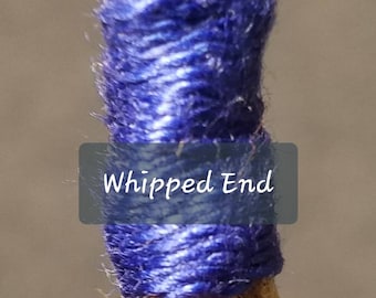 Peut inclure: Gros plan sur une corde en fibre naturelle avec une extrémité fouettée bleue. L'extrémité de la corde est enveloppée de fil bleu pour éviter l'effilochage. "Whipped End" est écrit sur une étiquette.