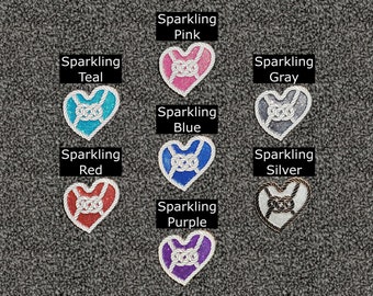 Peut inclure: Neuf ornements en forme de cœur scintillants avec des accents de corde blanche. Les cœurs sont de couleur sarcelle, rose, gris, bleu, rouge, argent et violet.