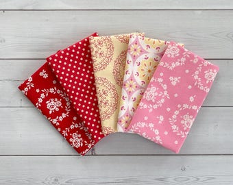May include: Six fabric squares with different patterns in shades of pink, red, and yellow. The patterns include polka dots, floral designs, and geometric shapes.