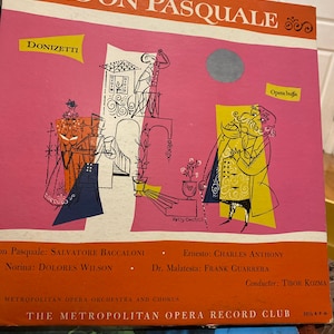 May include: A vintage record album cover for the opera Don Pasquale by Donizetti. The cover features a colorful illustration of characters from the opera, including a man in a red coat and a woman in a blue dress. The album is from The Metropolitan Opera Record Club.