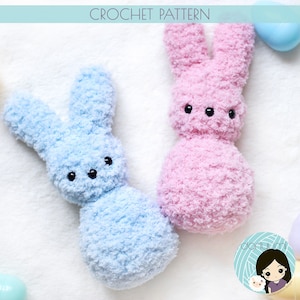 May include: Two crocheted bunny plushies, one light blue and one pink, with black eyes. The bunnies are made with a fluffy yarn and have a simple, rounded shape.