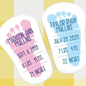 May include: Two baby footprint cards, one pink and one blue, with the names Madison Ann Mullins and Taylor Ryan Mullins, birth dates, weights, and lengths.