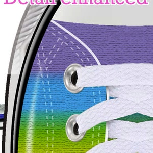 May include: Close-up of a rainbow-colored canvas shoe with white laces. The shoe has a purple, blue, green, yellow, and red stripe pattern. The laces are threaded through metal eyelets.