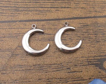 May include: Two silver crescent moon charms with a loop at the top for attaching to jewelry or other crafts.