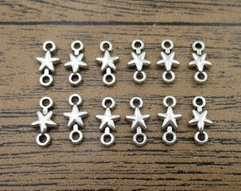 May include: Twelve silver-toned star-shaped connector charms with two jump rings each. The charms are arranged in two rows of six.
