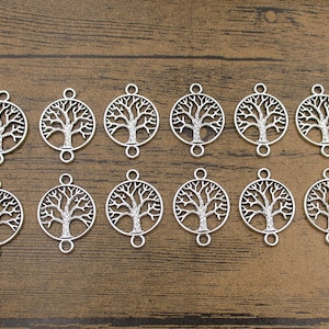 Puede incluir: Doce abalorios de metal plateados en forma de árbol de la vida. Cada abalorio tiene dos agujeros para sujetarlo a joyas u otras manualidades.