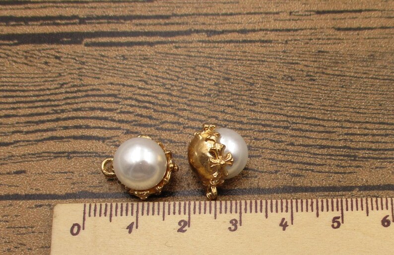 Puede incluir: Dos botones de n&aacute;car dorados con un dise&ntilde;o floral decorativo. Los botones miden aproximadamente 1 cm de di&aacute;metro y tienen un bucle en la parte posterior para coser.