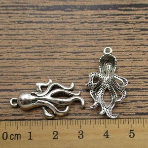 May include: Two silver octopus charms with detailed designs. The charms are approximately 2 cm in length and are perfect for jewelry making or crafting.
