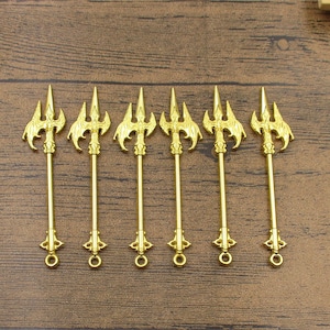 May include: Seven gold-colored tridents with decorative details. The tridents are about 10 cm long and have a ring at the bottom.