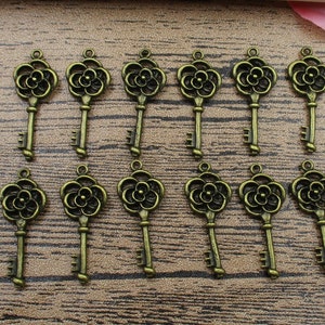 ¡VENTA AL POR MAYOR! 100 Dijes para Llaves, Llave de Flor, Bronce Antiguo, Doble Cara - RS059
