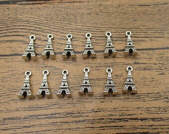 May include: A set of 14 silver Eiffel Tower charms. The charms are small and detailed, perfect for adding a touch of Parisian style to jewelry or crafts.