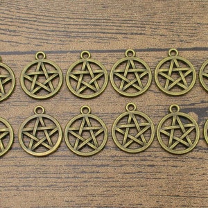 Könnte beinhalten: Ein Set mit 14 antiken goldfarbenen Metall-Anhängern mit einem fünfzackigen Stern-Design. Die Anhänger sind rund und haben oben eine Öse zum Anbringen an Schmuck oder anderen Bastelarbeiten.