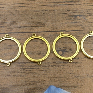 Puede incluir: Cinco marcos redondos de metal de color dorado con un acabado liso. Los marcos son todos del mismo tamaño y tienen un diseño simple.