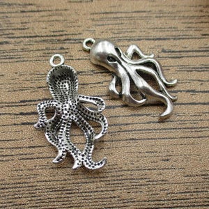 May include: Two silver octopus charms with detailed textured surfaces. The charms are perfect for jewelry making or crafting projects.