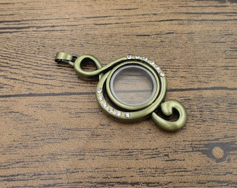 May include: A gold-toned music note charm with a clear glass locket and a row of clear rhinestones around the edge.