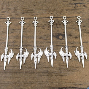 May include: Six silver-toned spear-shaped pendants with intricate details. Each pendant features a double-headed spear design with a pointed tip and a decorative handle.