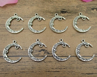 May include: Eight silver-toned crescent moon charms with intricate designs. The charms have a loop at the top for attaching to jewelry or other crafts.