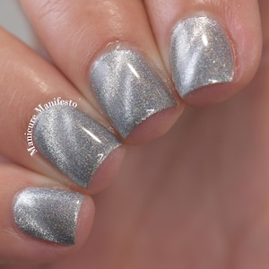 Puede incluir: Primer plano de uñas manicuradas con esmalte de uñas plateado y brillante. Las uñas son de forma cuadrada y reflejan la luz, creando un efecto brillante. El texto "Manicure Manifesto" es visible.