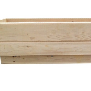 May include: A natural wood planter box with a rectangular shape. The planter is made of unfinished wood and has a simple design.
