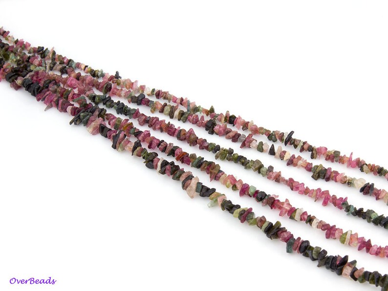 May include: A strand of multi-colored tourmaline chip beads. The beads are a mix of pink, green, and black.