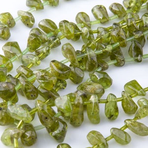 Puede incluir: Una hebra de cuentas de piedras preciosas verdes, cada cuenta tiene una forma irregular y &uacute;nica. Las cuentas est&aacute;n enhebradas en un hilo transparente.
