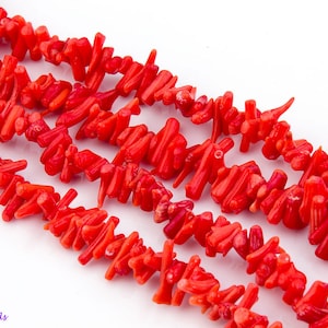 Peut inclure: Un brin de perles de corail rouge vif, chaque perle est de forme naturelle irrégulière. Les perles sont disposées en un motif lâche et fluide.