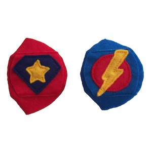May include: Two felt eye patches for kids. One is red with a blue and yellow star, the other is blue with a red and yellow lightning bolt.